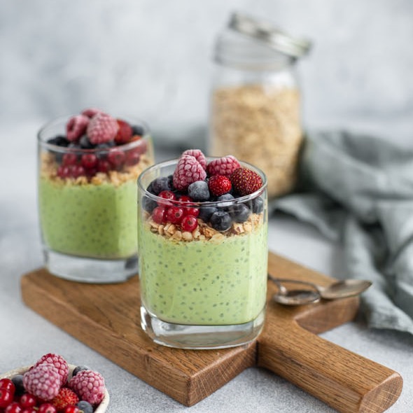 Grønn matcha chiapudding i glass med bær og granola